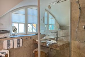 La salle de bains est pourvue d'une douche en verre et d'un lavabo. dans l'établissement Sonneninsel, à Zingst