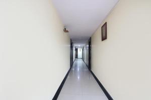 un corridoio in un edificio con pareti bianche e pavimenti bianchi di FabHotel Royal Residency II a Hyderabad
