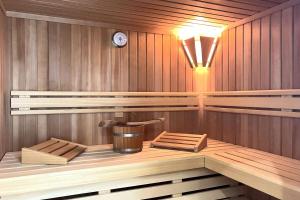 een sauna met een emmer en een klok aan de muur bij Strandhaus Zingst in Zingst