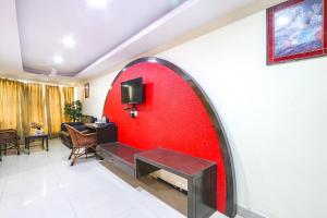 a red wall with a bench in a room at FabHotel Royal Residency Lakdikapul in Hyderabad