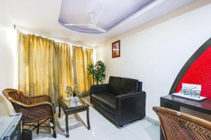 una sala de estar con una silla de cuero negro y una mesa en FabHotel Royal Residency II, en Hyderabad
