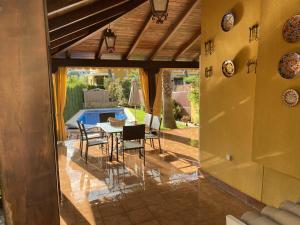 a patio with a table and chairs and a pool at Casa la Querencia del Lago Alojamiento Rural in Las Jaras