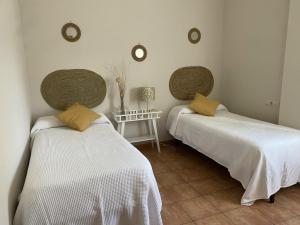 Las Jaras的住宿－Casa la Querencia del Lago Alojamiento Rural，客房设有两张床、一张桌子和镜子。