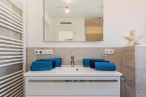 a bathroom with a white sink with blue towels at Sonnenaufgang in Zingst