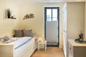 a bedroom with a white bed and a window at Wellenflüstern in Zingst