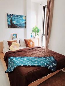 a bedroom with a large bed with two teddy bears on it at Airhub Hostel Phuket Airport in Ban Bo Han