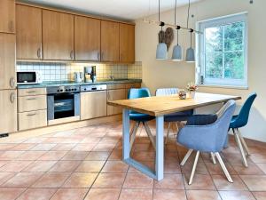 a kitchen with a wooden table and blue chairs at Weststrandläufer in Wieck