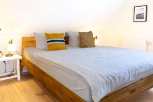 a bedroom with a large bed with yellow and blue pillows at Zum Schwedenblick in Groß Kirr