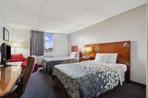 a hotel room with two beds and a television at Econo Lodge Inn & Suites in Waterloo +19 photos