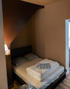 a bed with two pillows on it in a room at Le petit boulanger, grand 70 m2, garage disponible in Mulhouse