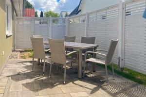 a table and chairs on a patio with a fence at Windspiel in Zingst