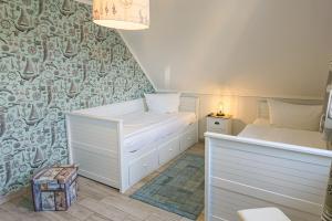 a small room with two beds and a wall at Windspiel in Zingst