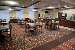 uma sala de jantar com mesas e cadeiras num tapete em Quality Suites Midland North Loop 250 em Midland