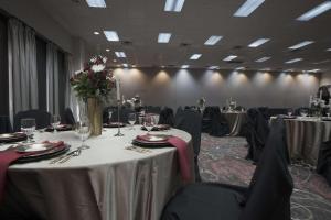 una sala de conferencias con mesas y sillas con flores. en Tanglewood Resort, Ascend Hotel Collection, en Pottsboro