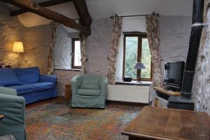 sala de estar con sofá azul y TV en Ghyll Burn Cottage and Barn End Cottage, en Alston