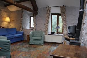 a living room with a blue couch and a tv at Ghyll Burn Cottage and Barn End Cottage in Alston
