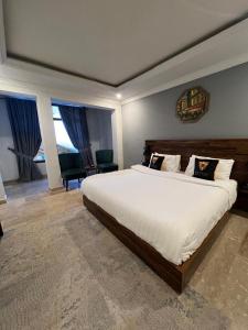 a bedroom with a large white bed and two windows at BULAND HEIGHTS in Murree