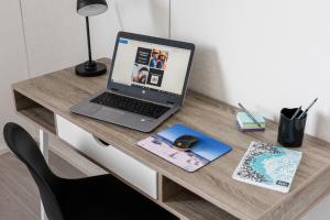 a laptop computer sitting on top of a wooden desk at Apartments Borg Kalskeentie in Pori