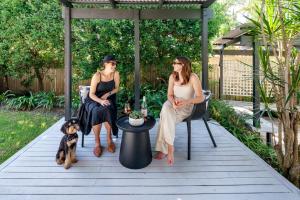 two women sitting on a porch with a dog at Battery Hill Pet-Friendly Poolside Paradise in Caloundra +53 photos