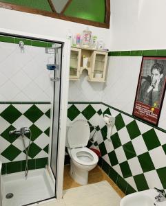 a bathroom with a toilet and a checkered wall at Casa Lucas in Tetouan