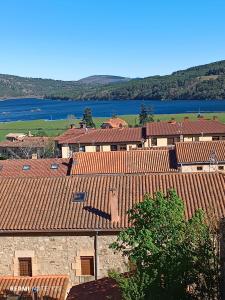 un grupo de edificios con techos rojos y un lago en Apartamento Mirador del Pantano 1 en Vinuesa