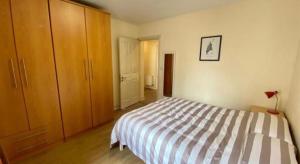 1 dormitorio con 1 cama y armarios de madera en CamdenWharf en Cork