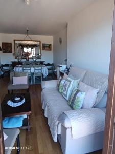 sala de estar con sofá blanco y mesa en Apartamento Mirador del Pantano 1 en Vinuesa