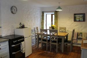 cocina y comedor con mesa y sillas en Ghyll Burn Cottage and Barn End Cottage, en Alston