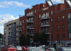 a large red brick building with cars parked in front of it at CamdenWharf in Cork