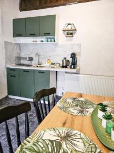 cocina con armarios verdes y mesa de madera en Guest Rooms- KLEPALSKI House, en Borovets