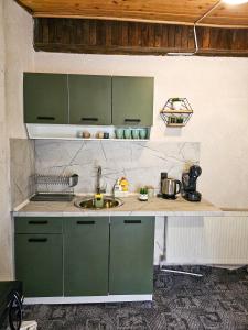 a kitchen with green cabinets and a sink at Guest Rooms- KLEPALSKI House in Borovets