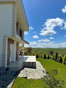 a white house with a patio and green grass at Villa Arisi in Pristina