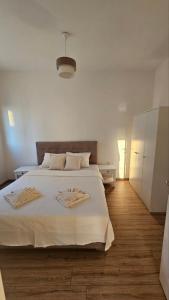 1 dormitorio con 1 cama blanca y 2 toallas en Apartments Radoman en Ulcinj