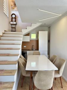 a kitchen and dining room with a white table and stairs at Villa Arisi in Pristina