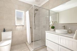 een badkamer met een douche, een toilet en een wastafel bij Cathy's Cottage in Cairns