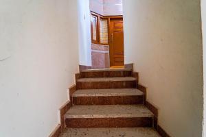 an empty hallway with stairs and a wooden door at FabHotel S V Homestay Tirupati in Tirupati