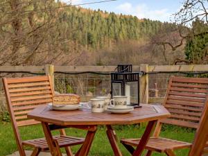 a wooden table with two chairs and a lantern at 2 Bed in Lydbrook 55961 in Lydbrook