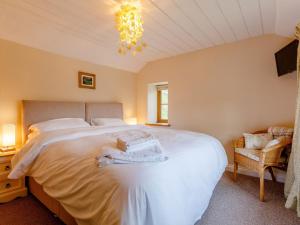 a bedroom with a large white bed and a chandelier at 2 Bed in Lydbrook 55961 in Lydbrook