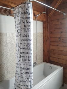 y baño con bañera y cortina de ducha. en HenFeverSicily Chalet Colapesce en Casa Modica