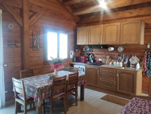 una cocina con armarios de madera y una mesa con sillas. en HenFeverSicily Chalet Colapesce en Casa Modica