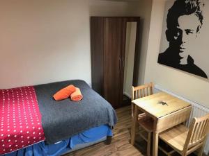 a bedroom with a bed and a wooden table at Studio flat London in London