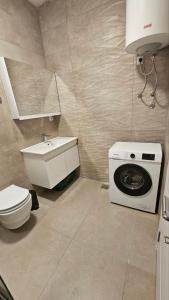 y baño con lavabo y lavadora. en Apartments Radoman, en Ulcinj