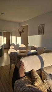 sala de estar con mesa, sillas y almohadas en Apartments Radoman en Ulcinj