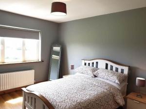 a bedroom with a white bed and a window at Hillside House in Ballinaboy