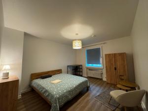 ein Schlafzimmer mit einem Bett, einem Stuhl und einem Fenster in der Unterkunft Hotel Am Ehrenhof in Düsseldorf