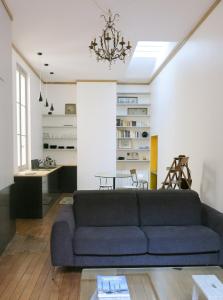 a living room with a couch and a table at Studio atypique au cœur du Bordeaux historique in Bordeaux