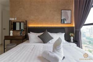 a bedroom with a large white bed with a window at Trion @ KL in Kuala Lumpur