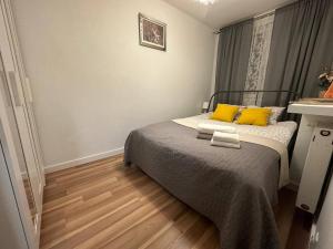 um pequeno quarto com uma cama com almofadas amarelas em 5Centrum Stanislawa Moniuszki10 Wi-fi 1Gb sek em Varsóvia