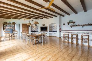 una cucina e una sala da pranzo con tavolo e sedie di Villa Maricel a Sant Feliu de Guíxols
