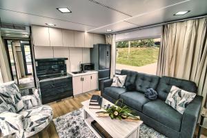 an rv living room with a couch and a table at Brand New House Boat Stunning Views and Resort Amenities in Merritt Island